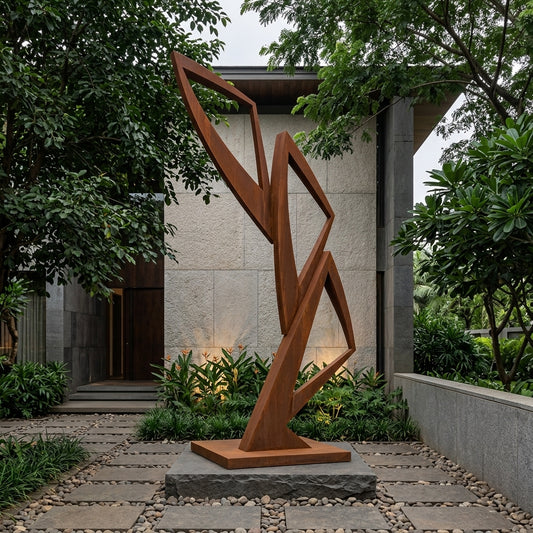 Abstract metal sculpture in a garden setting with a building in the background