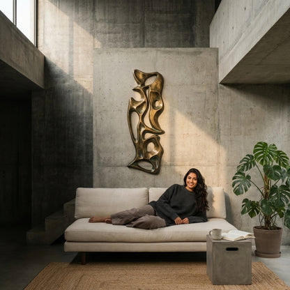 Woman sitting on a white sofa in a modern living room with abstract wall art and a plant.