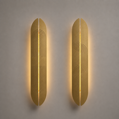 Two brass wall sconces with a geometric design on a gray wall.