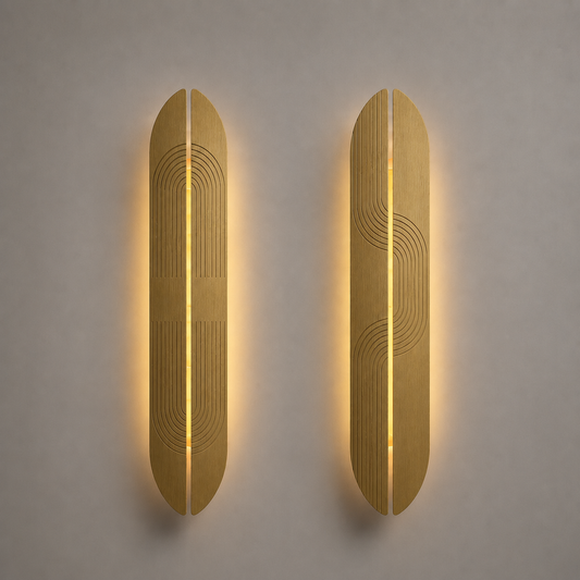 Two brass wall sconces with a geometric design on a gray wall.