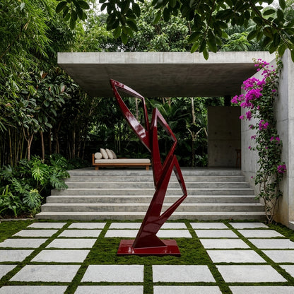 Red abstract sculpture in a garden setting with steps and greenery
