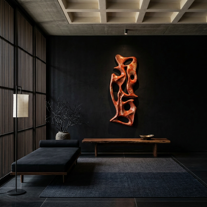 Modern interior with a dark wall, black sofa, and abstract orange sculpture.